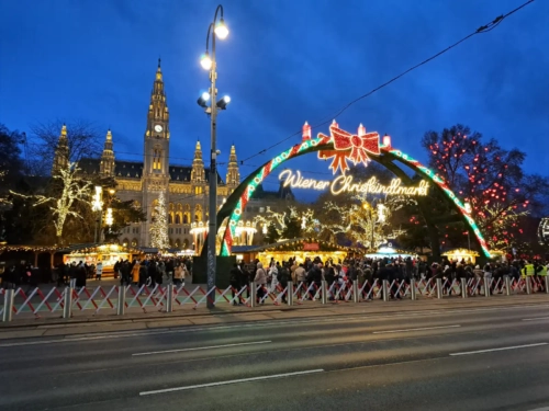Osvetljena bečka gradska kuća (Rathaus) i ulaz na Wiener Christkindlmarkt, najveći božićni vašar u Beču — putovanje sa Bee Travel